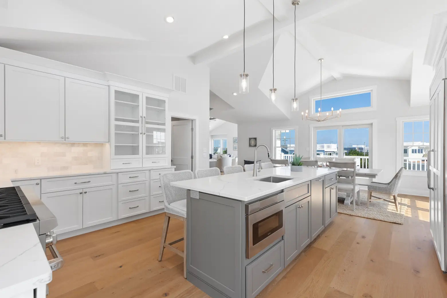 A modern kitchen featuring white cabinets and a spacious island, showcasing real estate photography excellence.