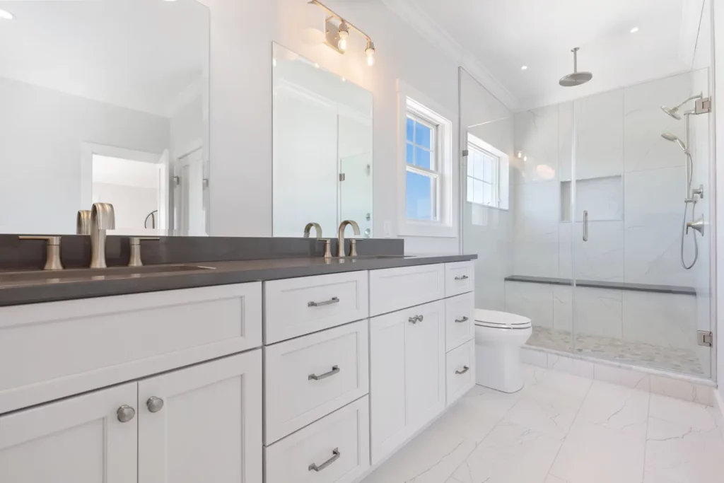 Stylish bathroom design with white cabinets and a walk-in shower.